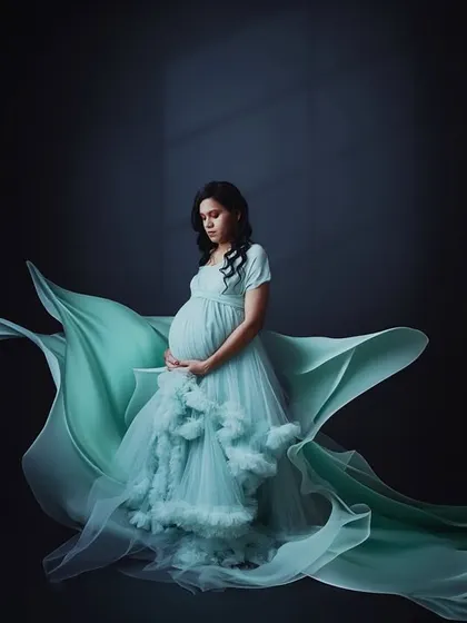 For those who dream of a dramatic and ethereal portrait, we use flowing fabrics and expert lighting to create breathtaking images. This shot captures the mom-to-be in a seafoam green gown with fabric that seems to float on air.