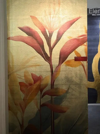 A stunning wall panel featuring a large, translucent floral design on a gilded background. The delicate botanicals seem to float on the metallic surface, creating a look of ethereal beauty and modern luxury.