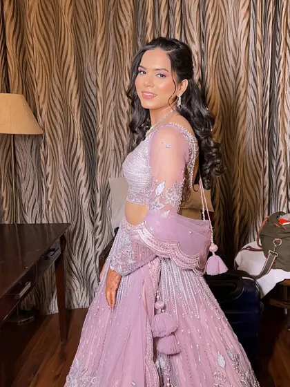 A full-length shot of Anu in her beautiful pastel lehenga. The soft curls and minimal accessories complete this elegant and modern engagement look.
