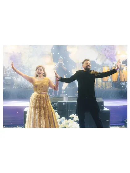 The couple shares a dance on stage, lost in their own world. The live band and sparkling lights create a romantic and lively ambiance for the Sangeet night in Phu Quoc.