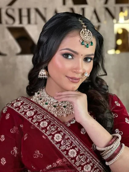 A close-up of the makeup and jewellery paired with the maroon velvet lehenga. The green-beaded kundan set provides a beautiful contrast.