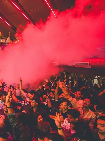 A cloud of red smoke fills the dance floor, creating a dramatic and immersive experience for everyone. This is how we make a night unforgettable.