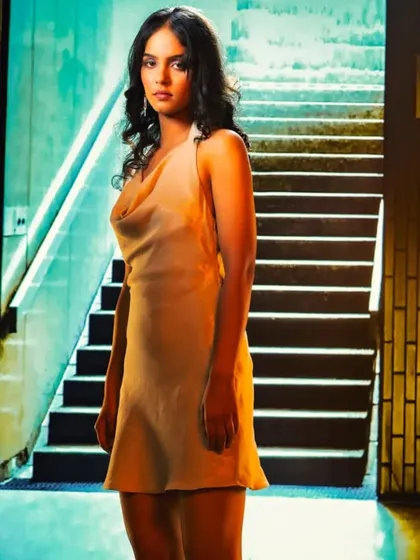 An urban subway station provides a gritty, modern backdrop through projection. The mixed lighting of the scene is used to create a moody and atmospheric portrait.
