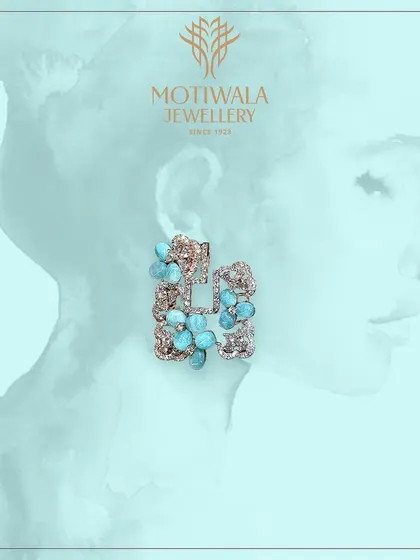 A pair of artistic and modern earrings featuring turquoise-colored floral elements within a diamond-paved frame. A unique piece for the fashion-forward individual.