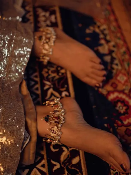 A detail shot focusing on the intricate anklets and sequined fabric from the 'Zamani' project. Every element of the styling was chosen to contribute to the overall story of a bride's anticipation.