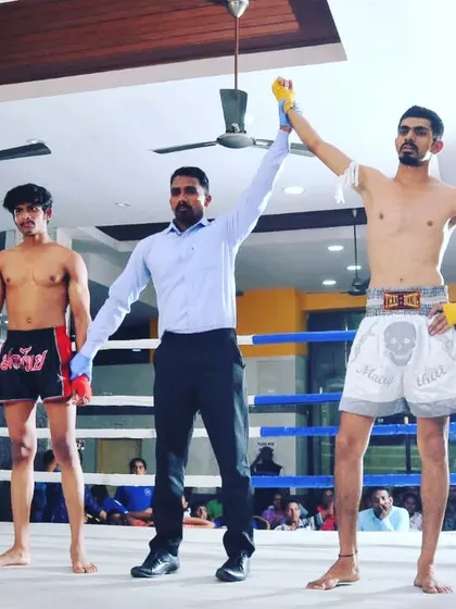 The referee raises our fighter's hand in victory at the South Indian National Muay Thai Pro Championship. A clear win and a gold medal earned.