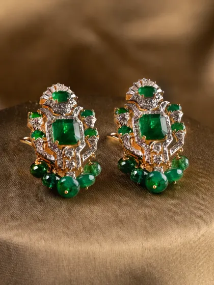 The Aurora Verde earrings, featuring structured emerald and diamond clusters with delicate emerald bead drops.