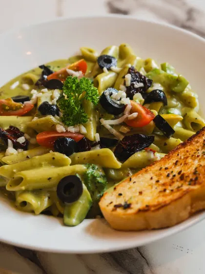 A close-up shot of a creamy pesto pasta dish, ready to be eaten. I focus on making the food the hero, using natural light and careful composition to emphasize its delicious details.