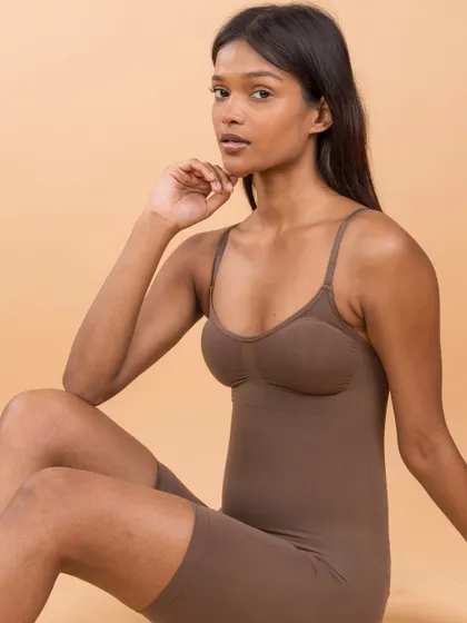 A poised and elegant shot showcasing a full-body shaper from Skkulpt. The clean background and simple pose put the focus squarely on the product's form and function.