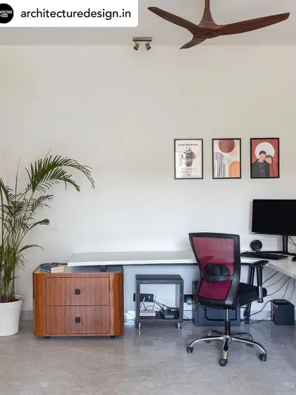 A functional and serene home office space. We used a clean, minimalist desk, ergonomic seating, and a touch of warmth with a wooden drawer unit to create a productive environment.