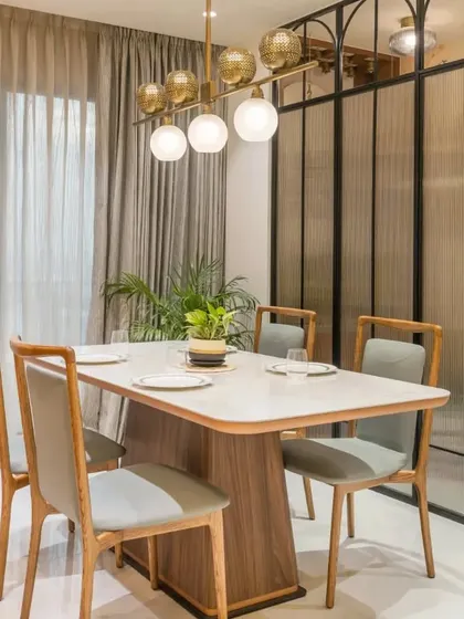Another view of the elegant dining space, showing the modern chandelier and comfortable upholstered chairs.