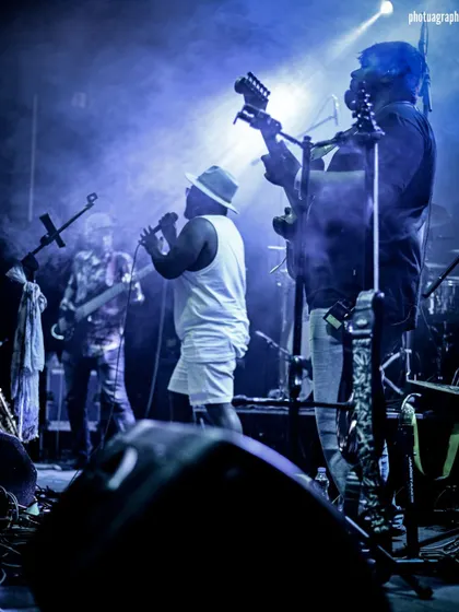 A powerful shot of the band under the lights. This is what a full-production live music event looks and feels like.