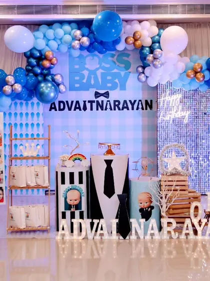 This Boss Baby first birthday setup includes a personalized milestone board and a photo collage, making the celebration extra special and unique.
