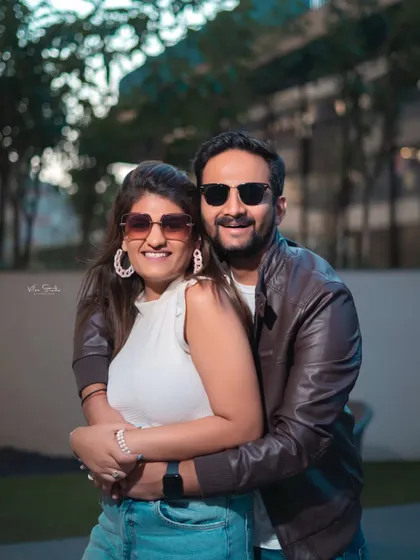 A happy, smiling portrait that radiates warmth and affection. The casual outfits and natural embrace make this a relatable and heartwarming couple photo.