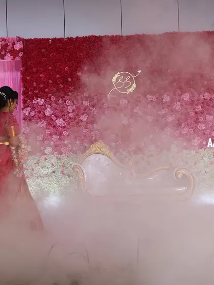 A wide shot of the pink ombre flower wall stage, showing the dramatic effect of the low lying fog we used for the couple's entrance. This effect adds a touch of magic and makes for incredible photographs.