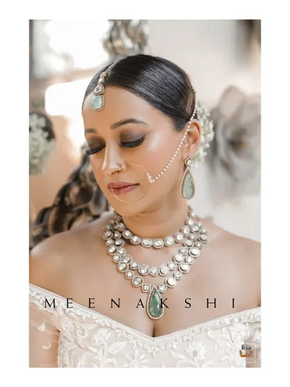 A glamorous bridal portrait showcasing her stunning off-shoulder blouse and layered necklace.