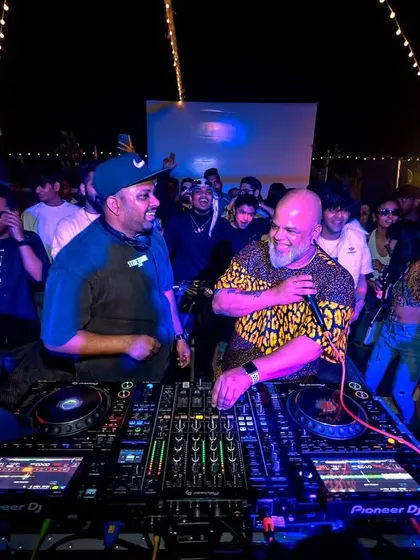 Two generations of DJs sharing the decks at the Block Party. It's all about respecting the culture and learning from the OGs.