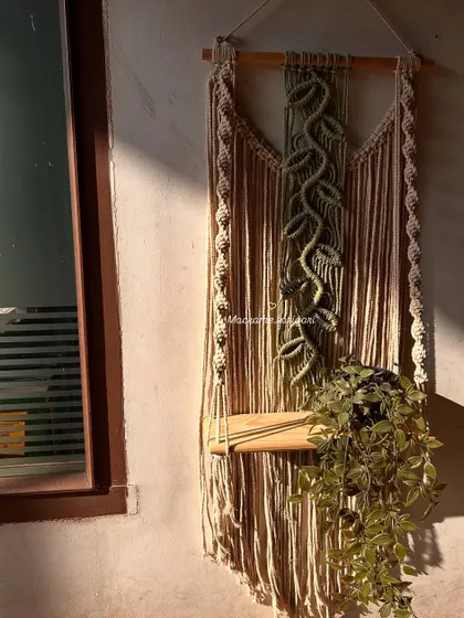 A quiet moment of work, with a macramé plant hanger catching the morning sun. It's in these simple moments that we find the most joy in our craft.