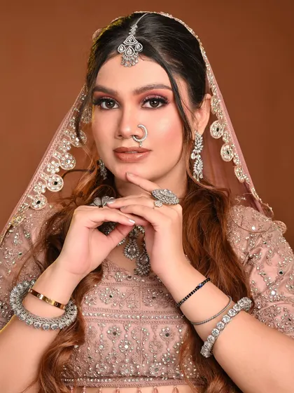 A front-facing shot that highlights the symmetry and balance of the makeup. The lip color is a perfect nude that complements the pink eye makeup.