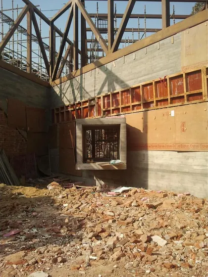 The Rhizome House during its construction phase. This image shows a cantilevered window box being formed, with the steel roof truss visible above.