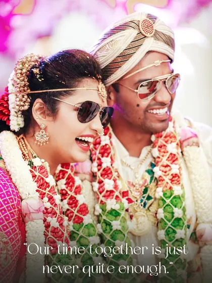 A cool and candid shot of the couple sharing a laugh while wearing sunglasses with their traditional wedding attire.