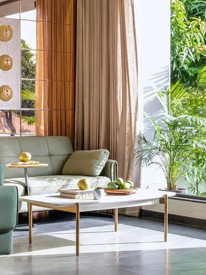 Here, you can see how the large window in the living room of Tranquil Mango Haven frames the vibrant green foliage outside. I design every view with intent, making the garden feel like a living piece of art that is part of the interior decor.