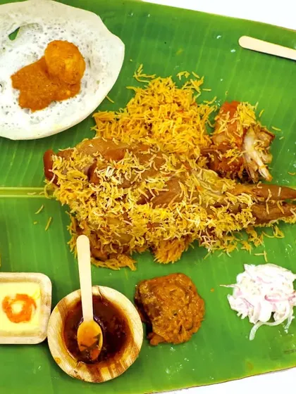 The complete Raja Virundhu plate, showcasing the variety we offer. From mutton leg and biryani to appam and sides, it's a full meal.