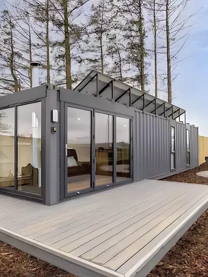 This container home is designed for energy efficiency, with solar panels installed on the roof. The large deck and glass facade make it an ideal choice for sustainable, modern living.