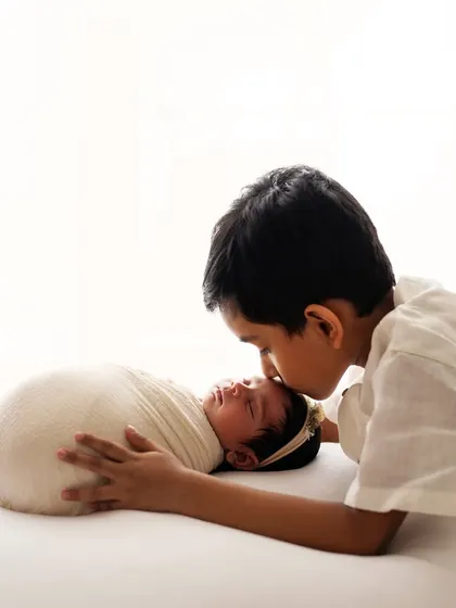 A gentle kiss for the new baby sister from her proud big brother. Sibling shots with a newborn are some of the most heartwarming photos to capture.