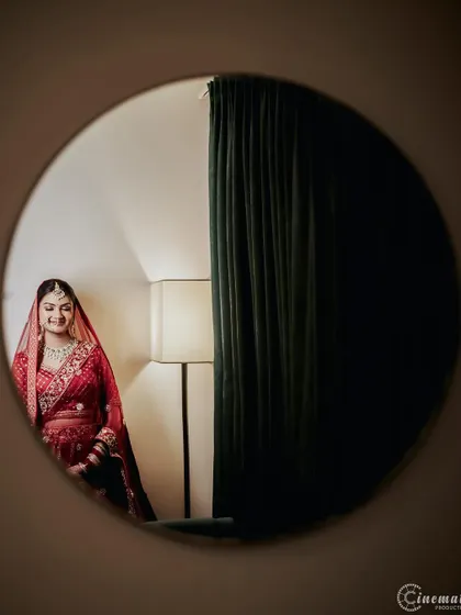 A creative bridal portrait using a mirror to frame the bride's reflection, creating an intimate and artistic feel.