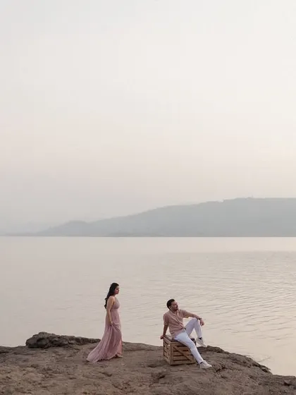 A minimalist and serene portrait of a couple by the vast expanse of Pawna Lake. The soft, hazy light and calm water create a tranquil and almost painterly quality in this pre-wedding photo.