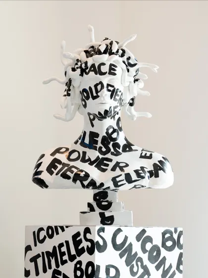 A frontal view of the Medusa bust, showcasing the powerful typography and the striking contrast of black and white.