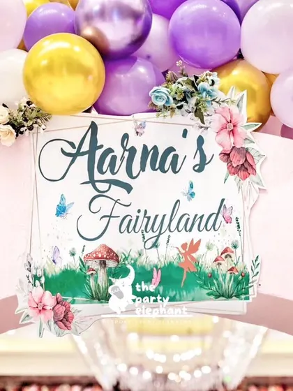 The custom "Aarṇa's Fairyland" welcome sign on the entrance arch, featuring beautiful floral and fairy illustrations.