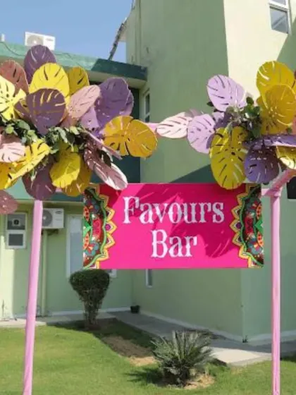 A bright and fun "Favours Bar" sign, adding a playful and interactive element to the Haldi or Mehndi function.