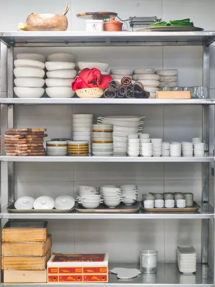A look inside my kitchen's storage, where our custom crockery is neatly stacked. Every plate and bowl is chosen with purpose to complement the food.