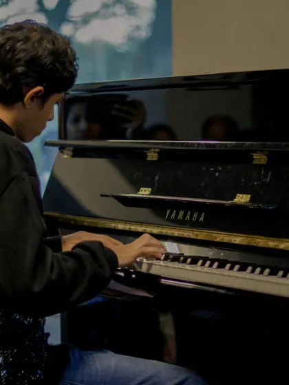 A student deep in concentration at the piano. The journey from the practice room to the recital stage is one we're proud to be a part of.