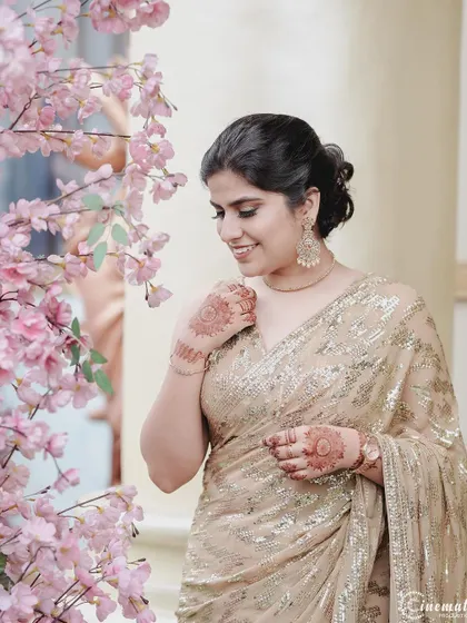 An elegant portrait of the bride-to-be, with soft pink cherry blossoms framing her, adding a touch of romance to the shot.