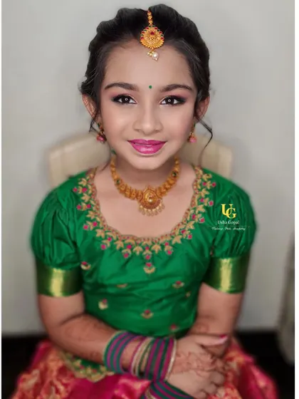 A beautiful portrait of Poorvi, looking like a little doll in her traditional pavadai davani (half saree) and jewelry. The makeup is kept light, fresh, and perfectly age-appropriate.