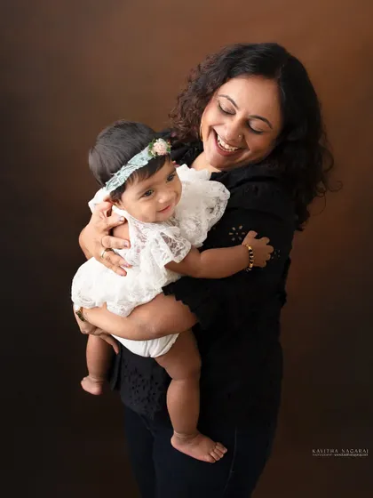 A mother and her eight-month-old daughter share a moment of pure joy. The baby's smile and the mother's laughter make this a truly heartwarming portrait.