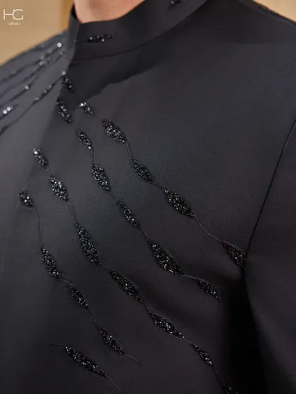 A macro view of the beadwork on the embroidered Achkan. Each bead is hand-stitched to create a flowing pattern that provides texture and a touch of understated opulence.