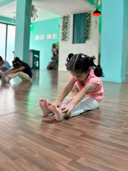 A little one concentrating hard on her forward fold. It's this focus that leads to amazing progress.