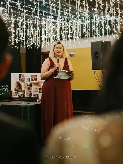 A guest delivers a heartfelt speech during the reception, with the beautiful fairy light canopy creating a magical atmosphere.