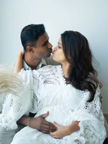 A sweet kiss shared between the parents-to-be. This candid moment is full of love and affection, a perfect memory of their time before baby arrives.