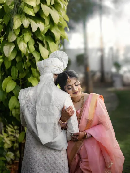 A gentle embrace in a sunlit garden. The bride's peaceful expression as she rests in her husband's arms speaks of trust, comfort, and love.
