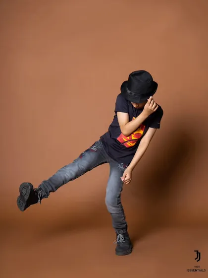 A cool, dance-inspired pose from a boys' fashion shoot. The hat and dynamic stance give this shot a great sense of style and movement.