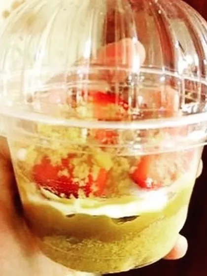 A single serving of my Strawberry Banoffee Pie in a cup. It has a buttery crust, delicious dolce de leche, sweet bananas, cream, and strawberries.
