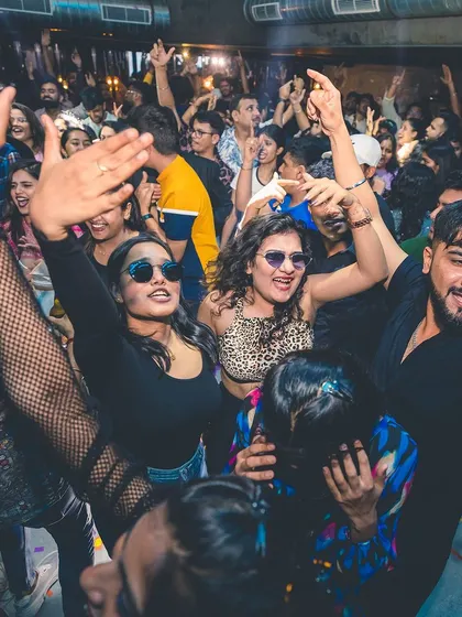 A packed dance floor with everyone smiling and dancing. The energy is infectious, and it's what I feed off all night.