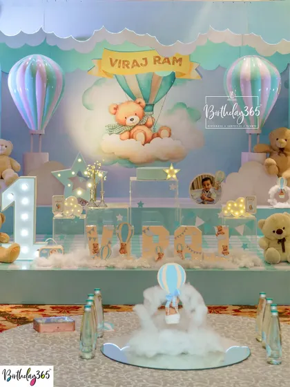 The main stage for Viraj Ram's first birthday, a dreamy setup with teddy bears, hot air balloons, and soft clouds.