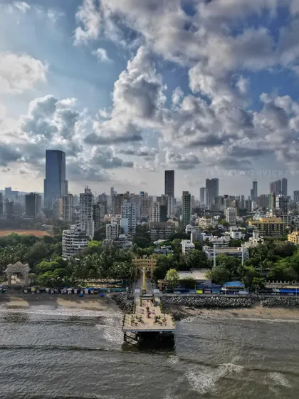 A clear aerial shot of the Mata Ramabai Ambedkar Smruti Viewing Deck at Dadar Chowpatty, showing its connection to the shore and the surrounding urban environment.