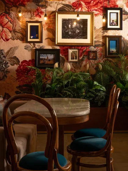 Another look at the maximalist corner at Echoes. The combination of bold wallpaper, eclectic art, and rich teal velvet chairs creates a space that is full of character and visual interest.
